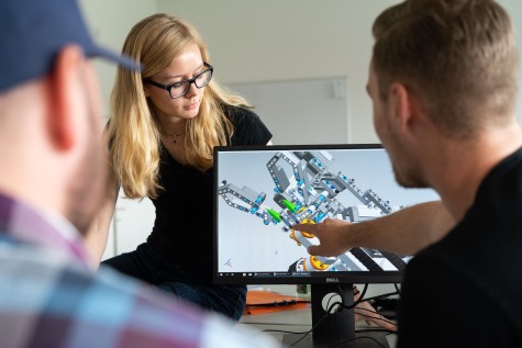 Eine Gruppe Studierender sieht sich ein 3D-Modell am Computer an.